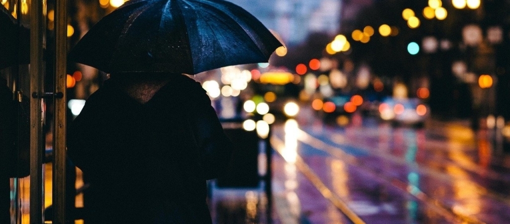 adulto bajo la lluvia ciudad oscura