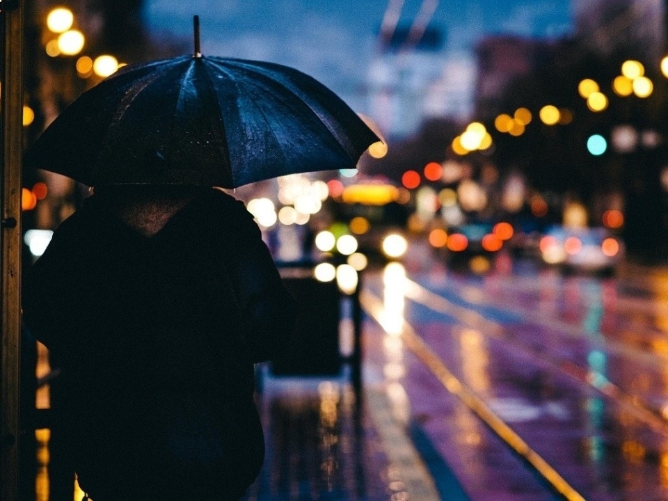 adult in the rain city dark
