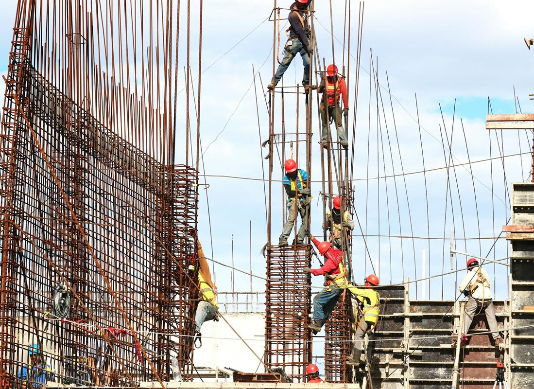 иностранные рабочие строят здание